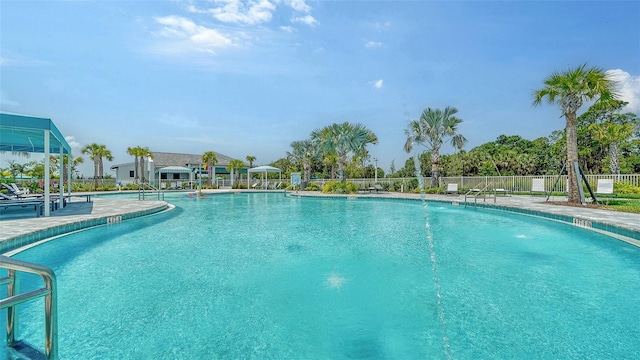 community pool with fence and a patio
