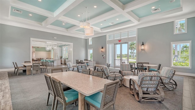 dining area with a towering ceiling, plenty of natural light, coffered ceiling, beam ceiling, and baseboards