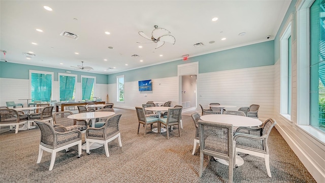 dining area with light colored carpet, a wainscoted wall, recessed lighting, a ceiling fan, and ornamental molding