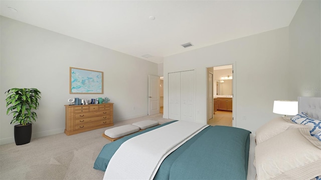 bedroom with light colored carpet, ensuite bath, a closet, and baseboards