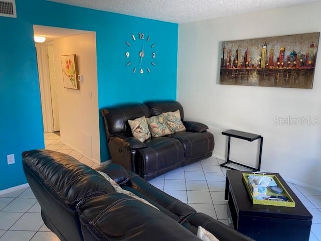 6157 E Midnight Pass Rd Unit B51, Sarasota, FL 34242 - tiled living area with a textured ceiling and baseboards