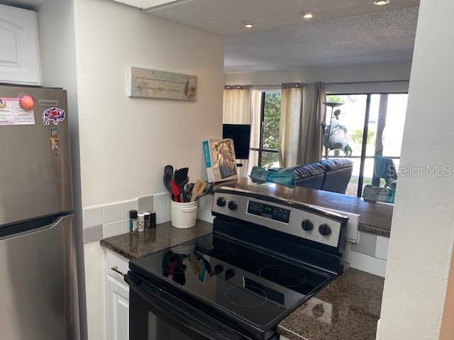 6157 E Midnight Pass Rd Unit B51, Sarasota, FL 34242 - kitchen with freestanding refrigerator, electric range, white cabinetry, and recessed lighting