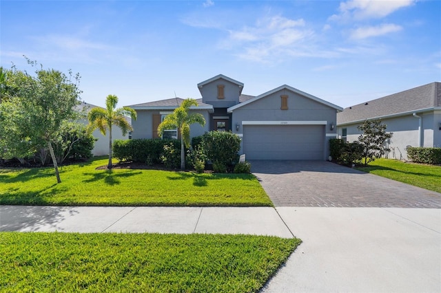 single story home featuring a garage, driveway, a front lawn, and stucco siding