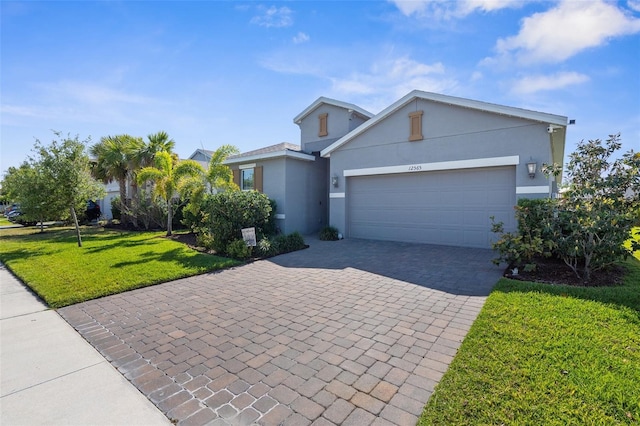 view of front of house featuring stucco siding, a garage, a front yard, and decorative driveway