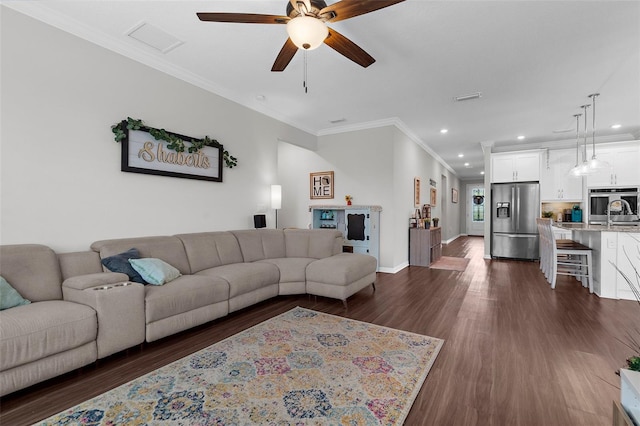 living room with ceiling fan, recessed lighting, ornamental molding, and dark wood finished floors