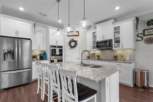 kitchen with a sink, tasteful backsplash, visible vents, glass insert cabinets, and appliances with stainless steel finishes
