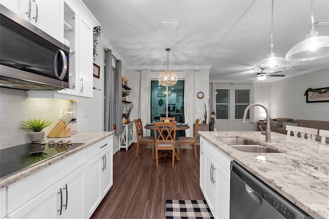 kitchen featuring tasteful backsplash, a sink, decorative light fixtures, dark wood finished floors, and appliances with stainless steel finishes