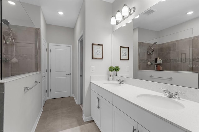 full bathroom featuring double vanity, visible vents, a sink, and a walk in shower