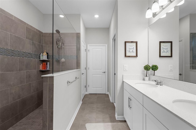 bathroom featuring walk in shower, a sink, double vanity, and tile patterned floors