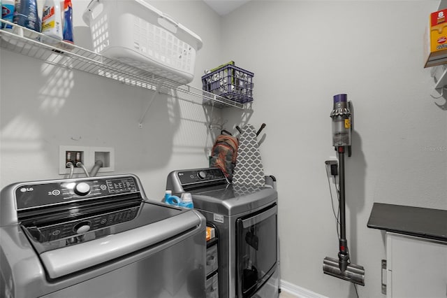 washroom featuring baseboards, independent washer and dryer, and laundry area