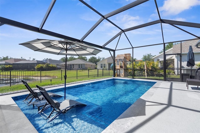 view of swimming pool featuring glass enclosure, fence, a patio, a fenced in pool, and a residential view