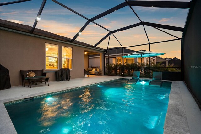 pool at dusk with glass enclosure, an outdoor pool, and a patio