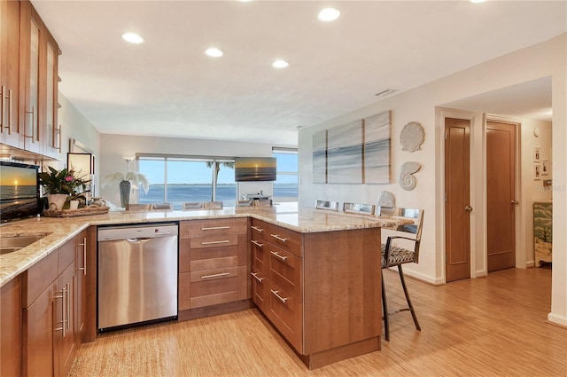 4800 Gulf Of Mexico Dr Unit 205, Longboat Key, FL 34228 - kitchen with stainless steel dishwasher, a peninsula, light wood-type flooring, light stone countertops, and recessed lighting