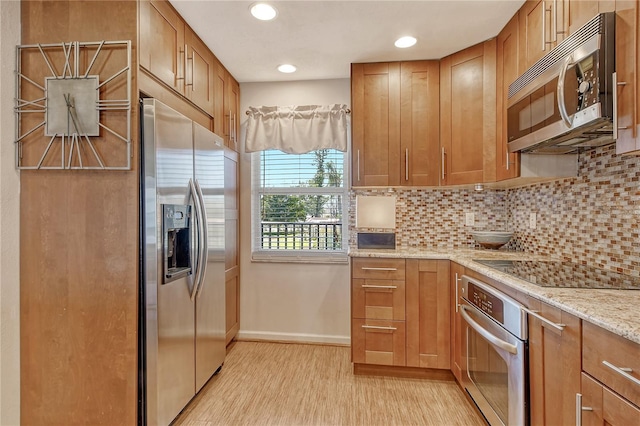 4800 Gulf Of Mexico Dr Unit 205, Longboat Key, FL 34228 - kitchen with appliances with stainless steel finishes, tasteful backsplash, recessed lighting, light wood-style flooring, and light stone countertops