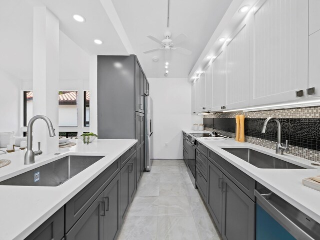 kitchen with a sink, appliances with stainless steel finishes, tasteful backsplash, light countertops, and recessed lighting
