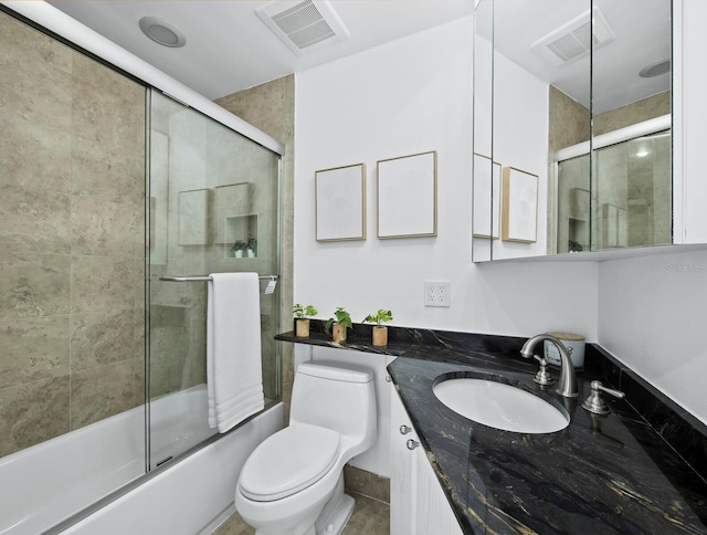 full bath with toilet, combined bath / shower with glass door, and vanity