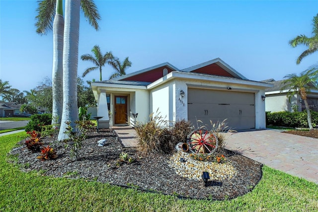 single story home featuring driveway, stucco siding, and an attached garage