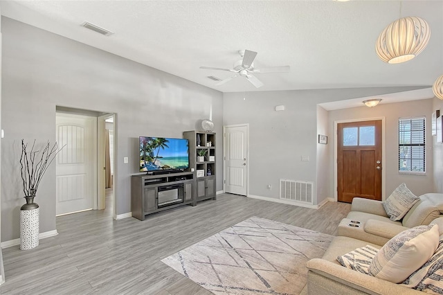 living area with baseboards, a ceiling fan, visible vents, and light wood-style floors