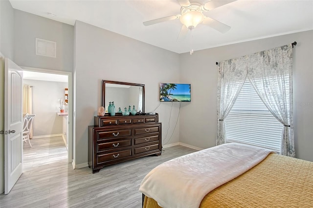 bedroom with baseboards, a ceiling fan, visible vents, and light wood-style floors