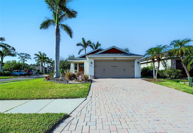 ranch-style home featuring stucco siding, a front lawn, an attached garage, and decorative driveway