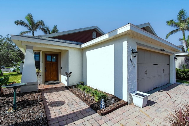 single story home with an attached garage, stucco siding, and driveway