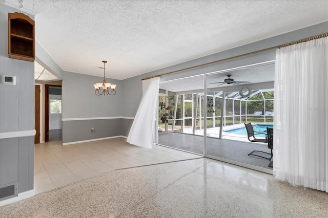 4311 52nd St E, Bradenton, FL 34208 - unfurnished room with a textured ceiling, visible vents, speckled floor, baseboards, and ceiling fan with notable chandelier