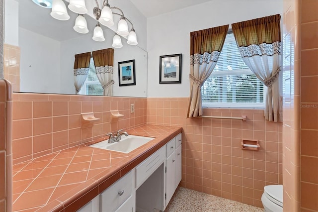 4311 52nd St E, Bradenton, FL 34208 - bathroom with tile walls, wainscoting, speckled floor, vanity, and toilet