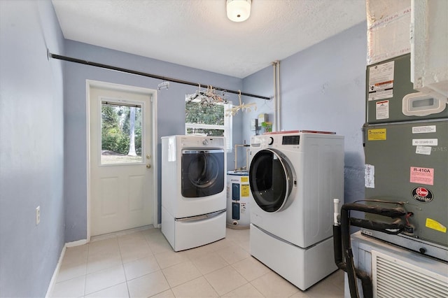 4311 52nd St E, Bradenton, FL 34208 - clothes washing area with independent washer and dryer, light tile patterned floors, laundry area, and baseboards