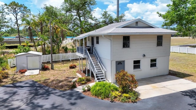 4311 52nd St E, Bradenton, FL 34208 - exterior space with fence, roof with shingles, an outbuilding, and a shed