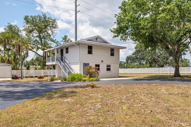 4311 52nd St E, Bradenton, FL 34208 - view of front facade featuring driveway, fence, a front yard, and stairway