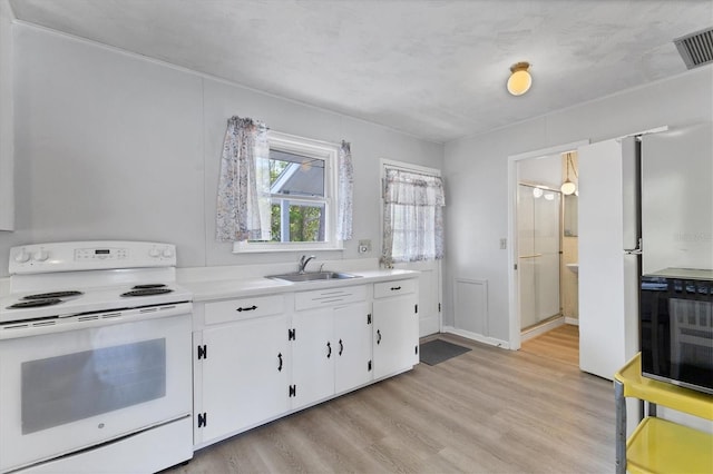 4311 52nd St E, Bradenton, FL 34208 - kitchen featuring visible vents, white range with electric cooktop, light wood-type flooring, white cabinets, and a sink