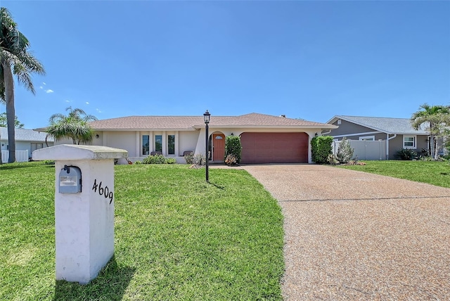 4609 Talbot Pl, Sarasota, FL 34241 - ranch-style home with a front lawn, concrete driveway, fence, an attached garage, and stucco siding