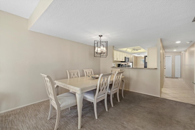 5780 Midnight Pass Rd Unit 410, Sarasota, FL 34242 - dining space with baseboards, a notable chandelier, a textured ceiling, and light colored carpet