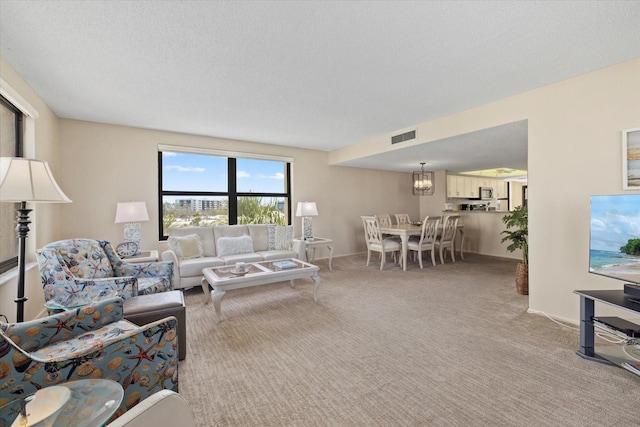 5780 Midnight Pass Rd Unit 410, Sarasota, FL 34242 - living room with visible vents, baseboards, a chandelier, and light carpet