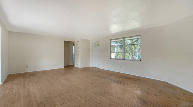 unfurnished room featuring baseboards and hardwood / wood-style floors