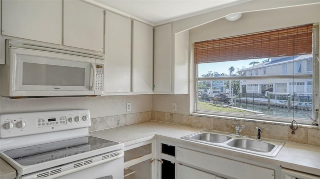 kitchen featuring a sink, light countertops, and white appliances