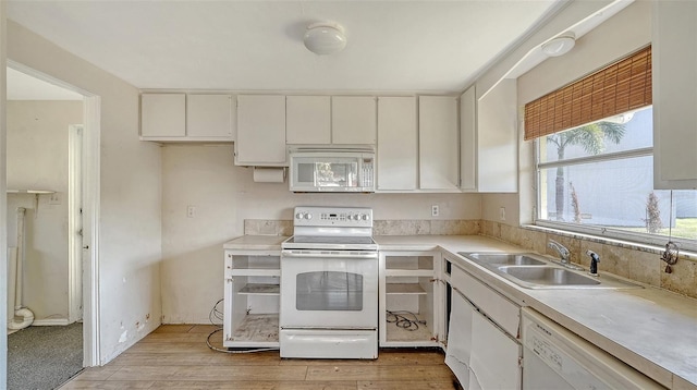 kitchen with white appliances, light wood-style floors, a sink, and light countertops