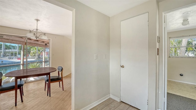 interior space with baseboards, an inviting chandelier, and light wood-style flooring