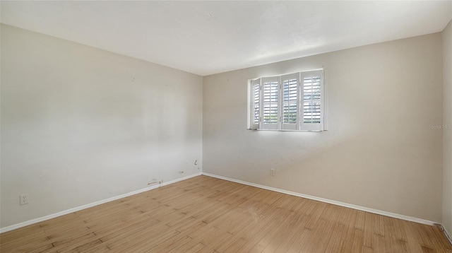 unfurnished room with baseboards and light wood-style flooring