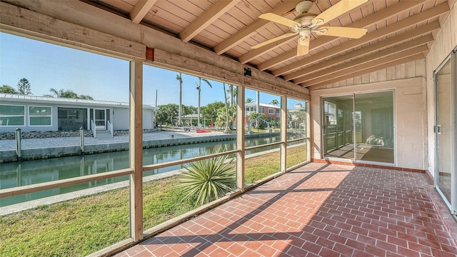 unfurnished sunroom with a water view, ceiling fan, and beamed ceiling