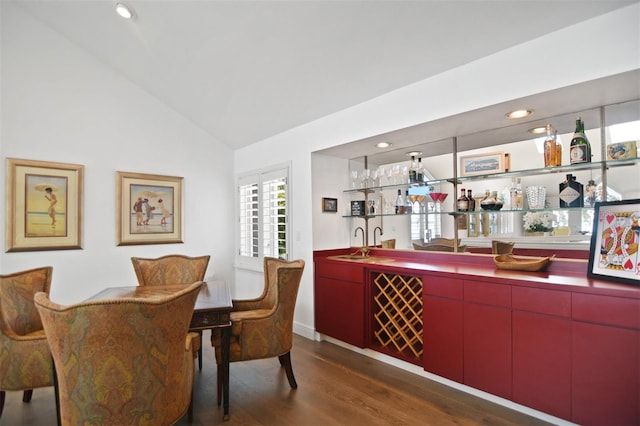 bar featuring a sink, recessed lighting, wet bar, wood finished floors, and vaulted ceiling