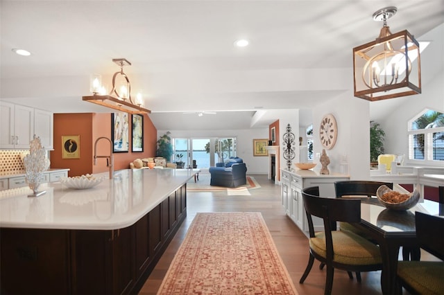 kitchen with light countertops, recessed lighting, open floor plan, a large island, and wood finished floors
