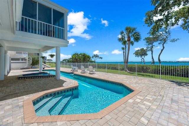 view of swimming pool with fence, a fenced in pool, an in ground hot tub, a water view, and a patio