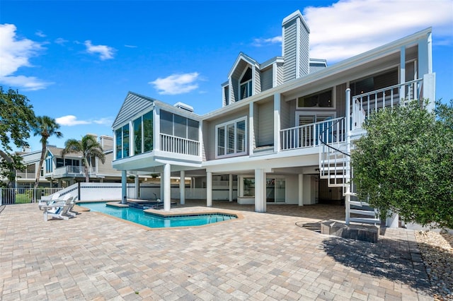 view of pool featuring stairs, a sunroom, a fenced in pool, and a patio