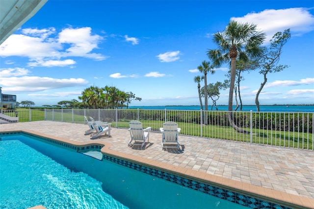 view of pool featuring a fenced in pool, fence, a water view, and a patio area