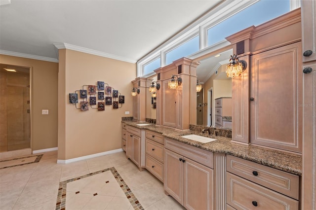 bathroom with double vanity, ornamental molding, baseboards, tiled shower, and a sink
