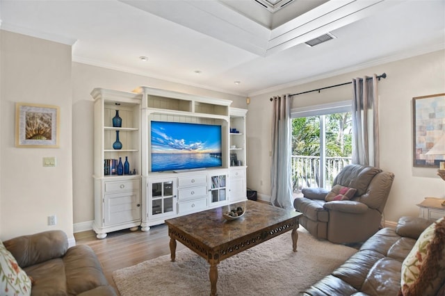 living room featuring baseboards, crown molding, wood finished floors, and visible vents