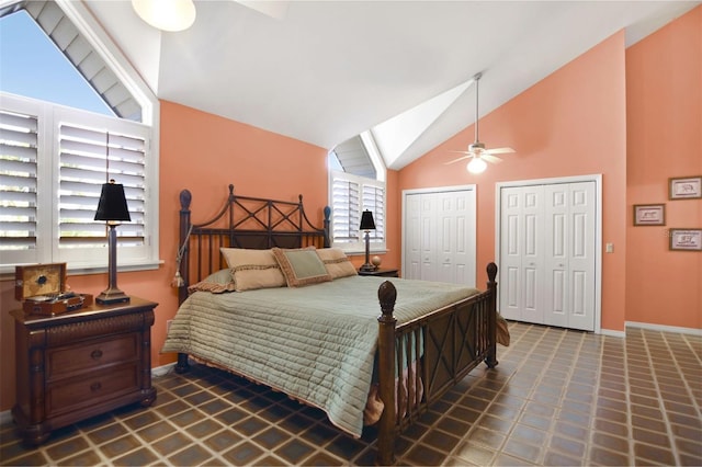bedroom with two closets, a ceiling fan, baseboards, and vaulted ceiling
