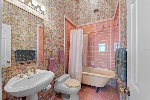 full bathroom featuring a sink, tile patterned flooring, wallpapered walls, and toilet