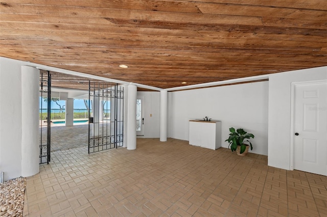basement featuring recessed lighting, brick patterned floor, and wooden ceiling